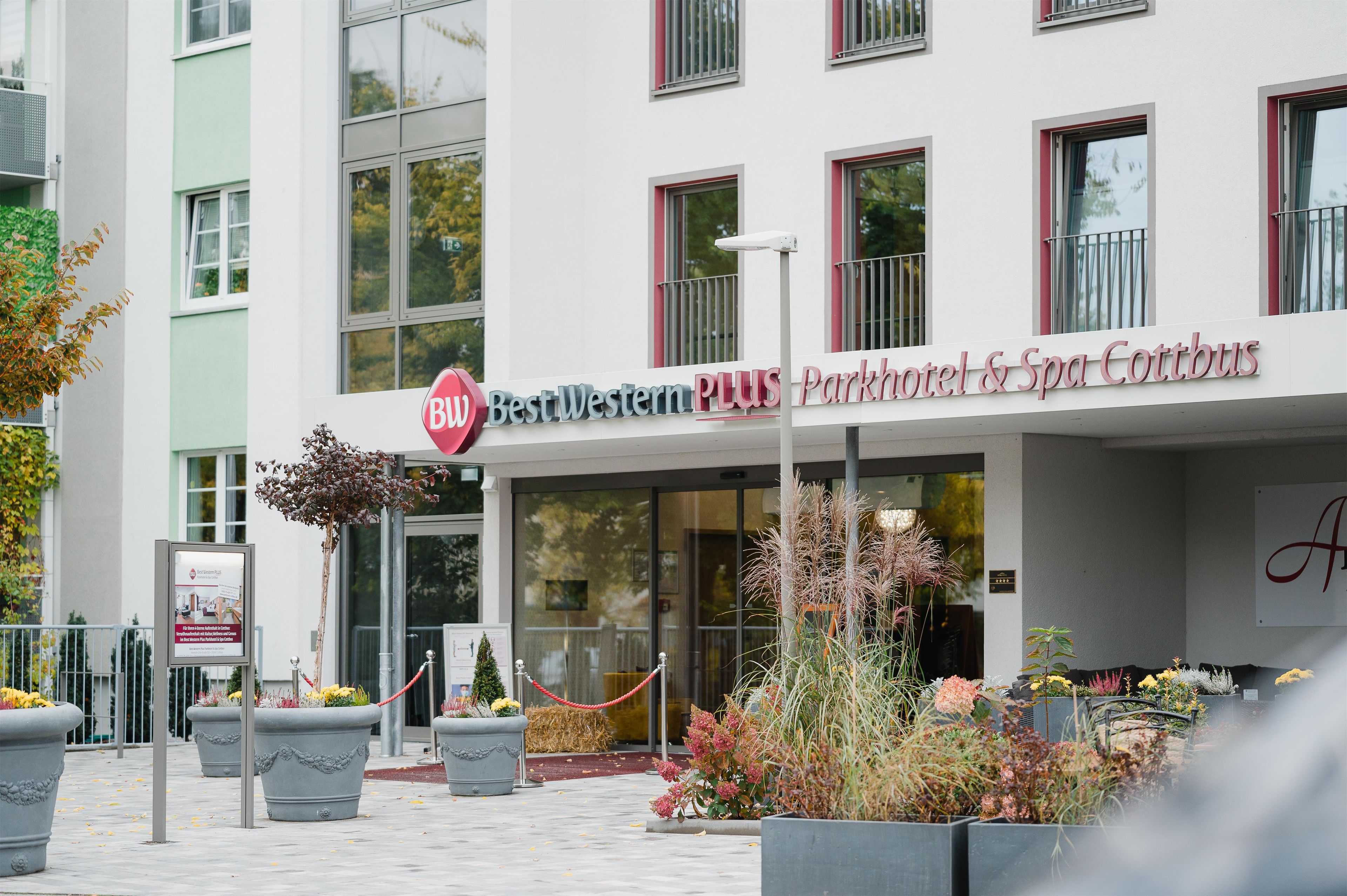 Ein Hotel Eingang mit einem Schild für 'Best Western PLUS Parkhotel & Spa Cottbus'.