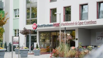 Entrada de un hotel con un letrero que dice 'Best Western PLUS Parkhotel & Spa Cottbus'.