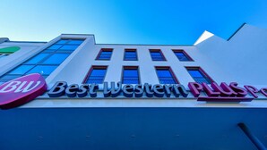 Un hotel con fachada moderna, amplias ventanas y llamativos letreros de 'Best Western Plus'.