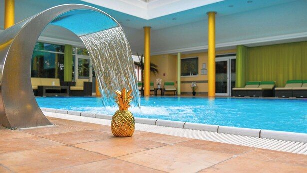 Una piscina interior con un elemento acuático y una decoración de piña.