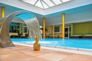 Una piscina techada, sillones reclinables de piscina