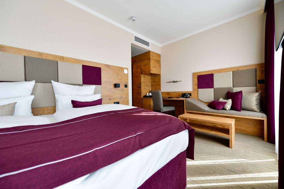 Een moderne hotelkamer met een groot bed, een bureau en een bank.