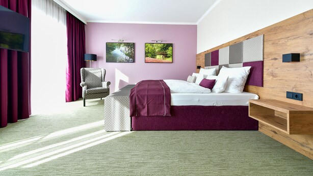 A modern hotel room with a large bed, a chair, and two framed pictures on the wall. - Best Western Plus Parkhotel & Spa Cottbus (Cottbus)