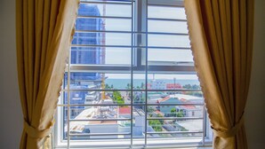 Ein Fenster mit Blick auf eine Stadtlandschaft, einschließlich Gebäude und eines Gewässers.