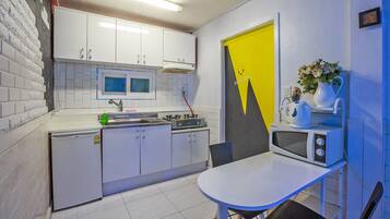 Kamer | Privรฉkeuken | Een koelkast, een microgolfoven, een kookplaat, een waterkoker