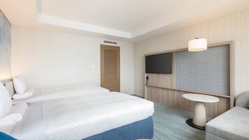 Una habitación de hotel con una cama, un escritorio, una silla, un televisor y una mesita.