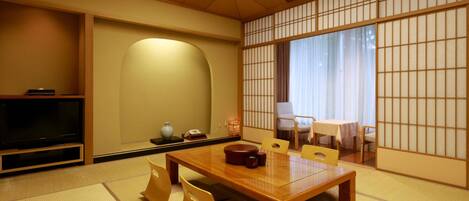 A traditional Japanese-style room with tatami flooring, a low wooden table, and a sliding shoji screen.