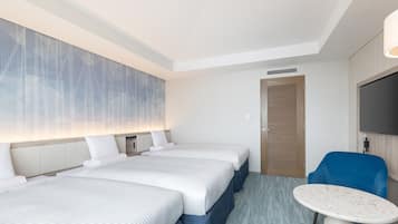 Une chambre d’hôtel avec deux lits, une télévision, un bureau et une porte.