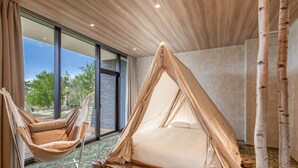 A room with a large window, a hammock, a tent-like bed, and birch trees. - KIYOSATO KOGEN RESORT (Hokuto)