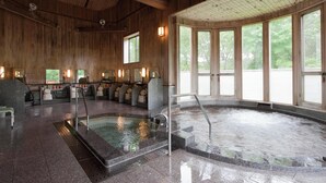 A spa area with a hot tub, seating, and large windows. - KIYOSATO KOGEN RESORT (Hokuto)