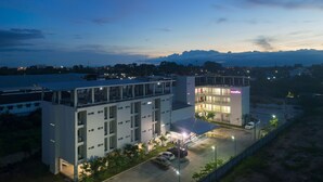 A multi-story hotel with a flat roof, multiple balconies, and a covered parking area. - Eco Inn Lite Nakhon Si Thammarat (Nakhon Si Thammarat)