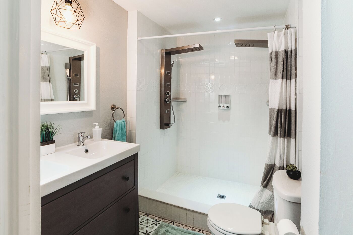 A modern bathroom with a shower, toilet, and sink.