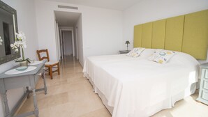 A bedroom with a bed, a desk, a chair, and a mirror. - Los Granados de la Duquesa 2022 (Manilva)