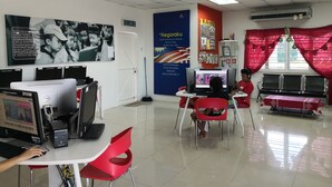 A classroom with computers, red chairs, and educational posters on the walls. - Kuala Mengalong Cottage (Sipitang)