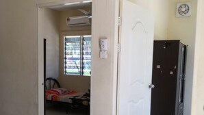 A room with a bed, a window, a door, and a refrigerator. - Kuala Mengalong Cottage (Sipitang)