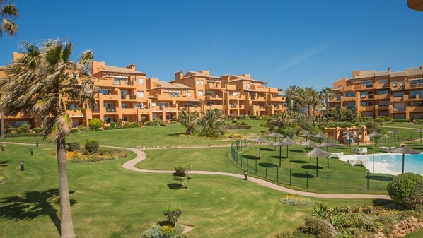 Ein Resort mit mehrstöckigen Gebäuden, einem Schwimmbad und gepflegten Rasenflächen und Gärten.