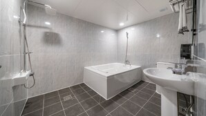 Uma casa de banho moderna com banheira, chuveiro e lavatório.