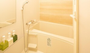 A bathroom with a bathtub, a shower, and a mirror. There are bottles of Green Tea shampoo on the wall. - 9 Hotel Hakata (Fukuoka)