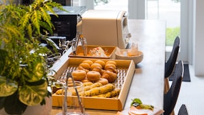A breakfast buffet with pastries and a coffee machine, a potted plant, and a view of the outdoors through large windows. - 9 Hotel Hakata (Fukuoka)