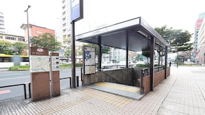 A covered bus stop with a map and information sign, located on a city sidewalk with buildings in the background. - 9 Hotel Hakata (Fukuoka)