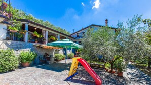 Un cortile con piscina, posti a sedere all'aperto e uno scivolo.