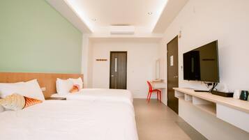 A hotel room with two beds, a desk, a TV, and a red chair.