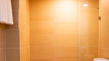 A modern bathroom with a toilet, a towel rack, and a shower area.