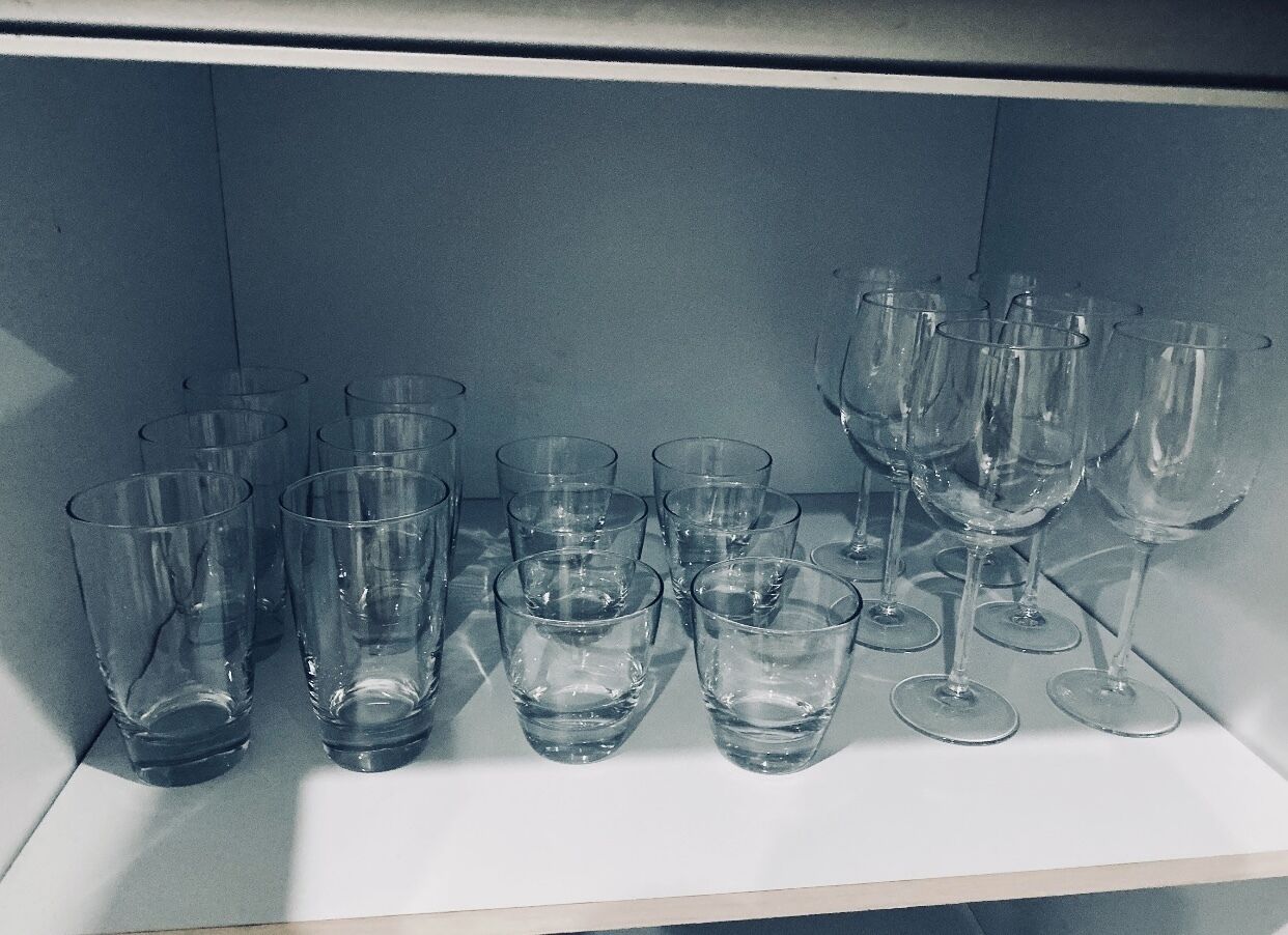Une étagère avec divers verres à vin et verres à cocktail vides.