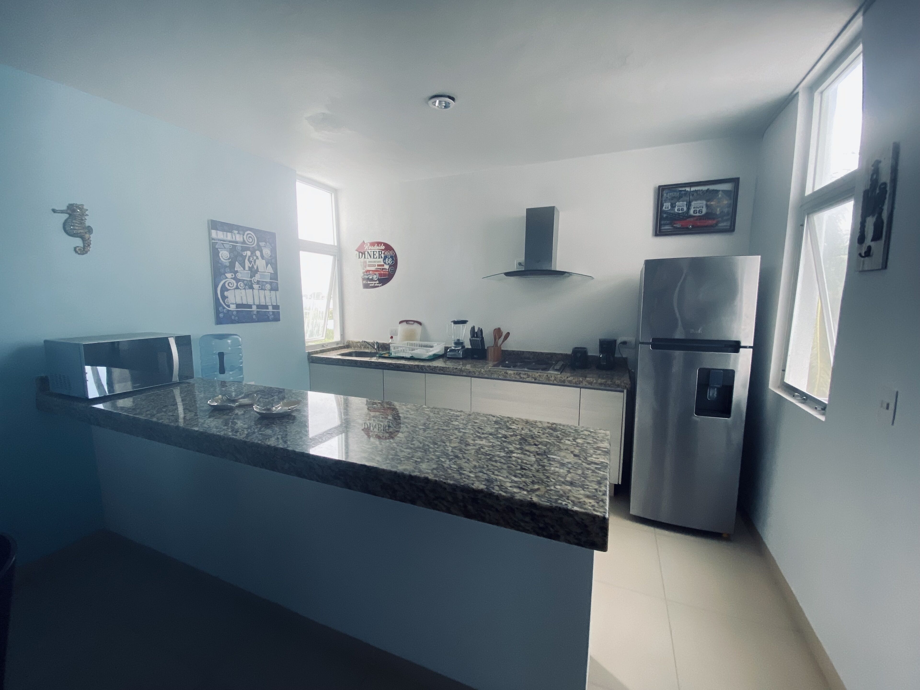A modern kitchen with granite countertops, stainless steel appliances, and a window providing natural light.