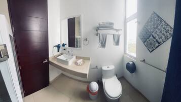 Deluxe appartement | Badkamer | Een douche, een haardroger, handdoeken, toiletpapier