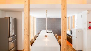 Una cucina moderna con isola centrale, travi in legno ed elettrodomestici in acciaio inossidabile.