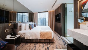 A modern hotel room with a large bed, a desk with a telephone, a bathroom with a marble sink, and large windows with curtains. - WOLO Kuala Lumpur (Kuala Lumpur)