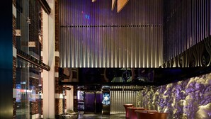 A modern lobby with a reflective floor, curved metallic structures, and a seating area with cushioned chairs. - WOLO Kuala Lumpur (Kuala Lumpur)