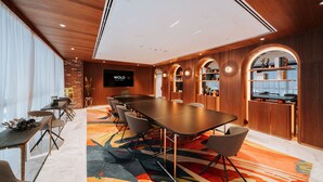 A conference room with a long table, chairs, a TV screen, and bookshelves. - WOLO Kuala Lumpur (Kuala Lumpur)