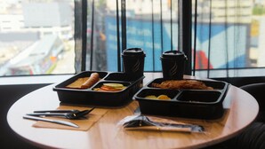 A table with food containers, two coffee cups, and cutlery. - WOLO Kuala Lumpur (Kuala Lumpur)