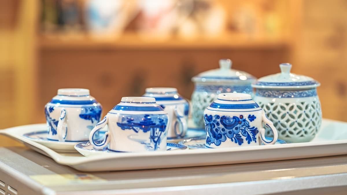 A tray with blue and white ceramic teapots and cups on a table.