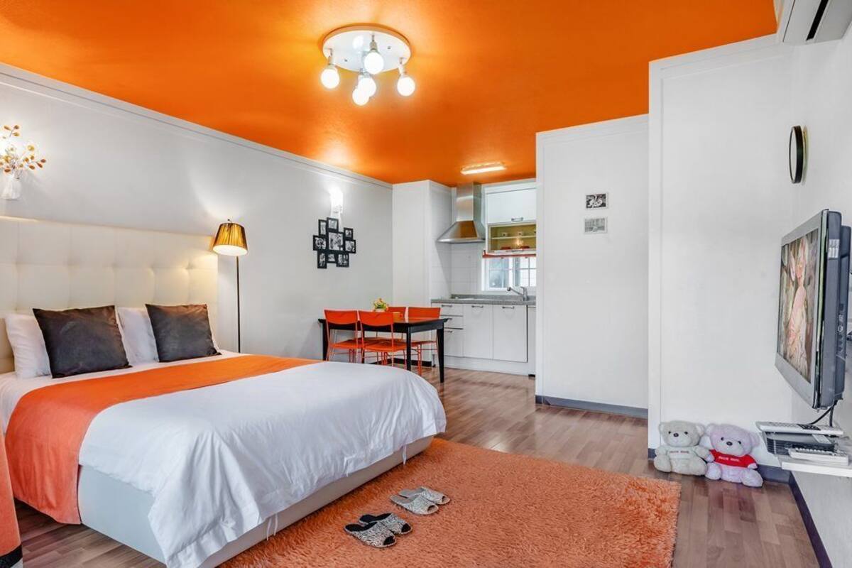 Un dormitorio con una cama grande, un escritorio y un televisor.