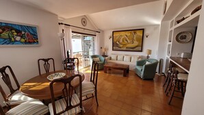 A living room with a dining table, chairs, a sofa, and a painting on the wall. - CASA VINCA, quiet holiday home near the beach (Puerto del Carmen)