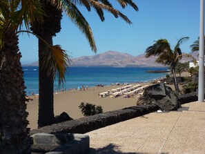 Ranta lähistöllä, aurinkotuoleja, rantapyyhkeitä