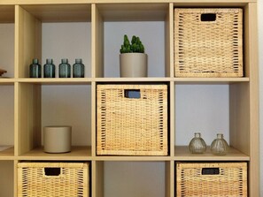 A wooden shelf with multiple wicker baskets and a potted plant.