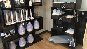 A hotel room with a black shelf displaying hair dryers, bottles, and a photo. There are also purple and white hair dryers on the floor. - Hotel Tsuchiura Kandatsu Hills (Tsuchiura)