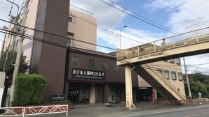 A hotel with a modern design, a visible entrance, and a pedestrian bridge overhead. - Hotel Tsuchiura Kandatsu Hills (Tsuchiura)