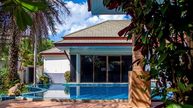 A modern house with a swimming pool, surrounded by tropical plants and a clear blue sky. - Big Comfortable Villa (Banglamung)