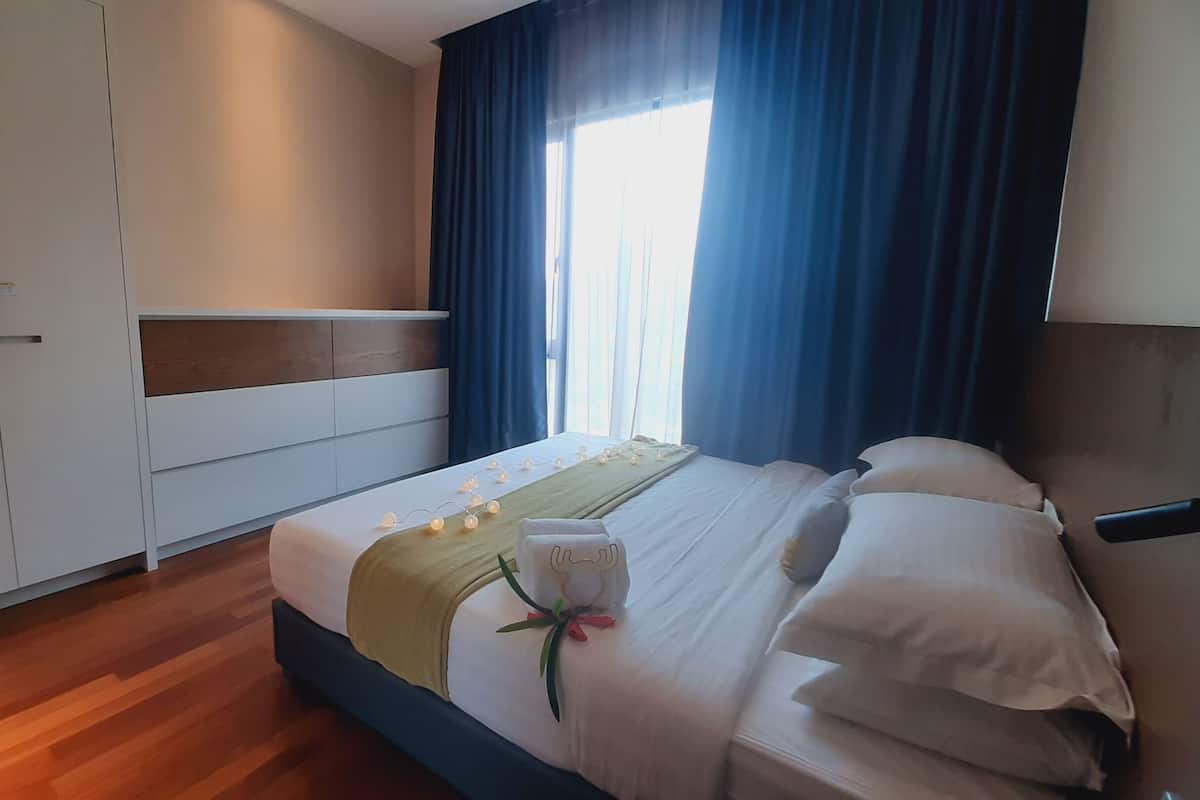 Ein Hotelzimmer mit Bett, Schrank und einem Fenster mit Vorhängen.