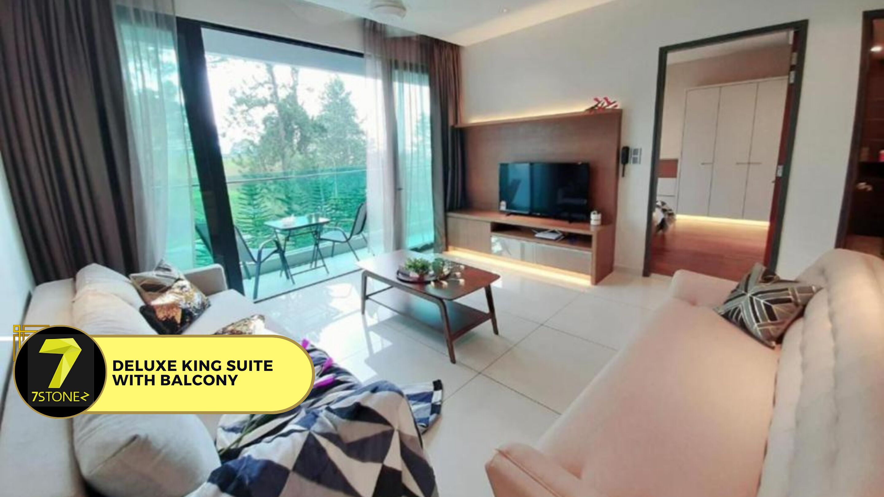A modern living room with a sofa, coffee table, TV, and balcony view.