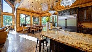 A spacious kitchen with granite countertops, stainless steel appliances, and a large island. - Jolly Roger Cabin | Pirate Ship Playground | Luxury Broken Bow Retreat (BROKEN BOW)