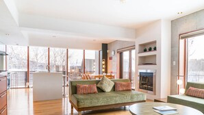A spacious living room with a green sofa, a round coffee table, and a fireplace. - Yuuki Toride Chalet (Kutchan)