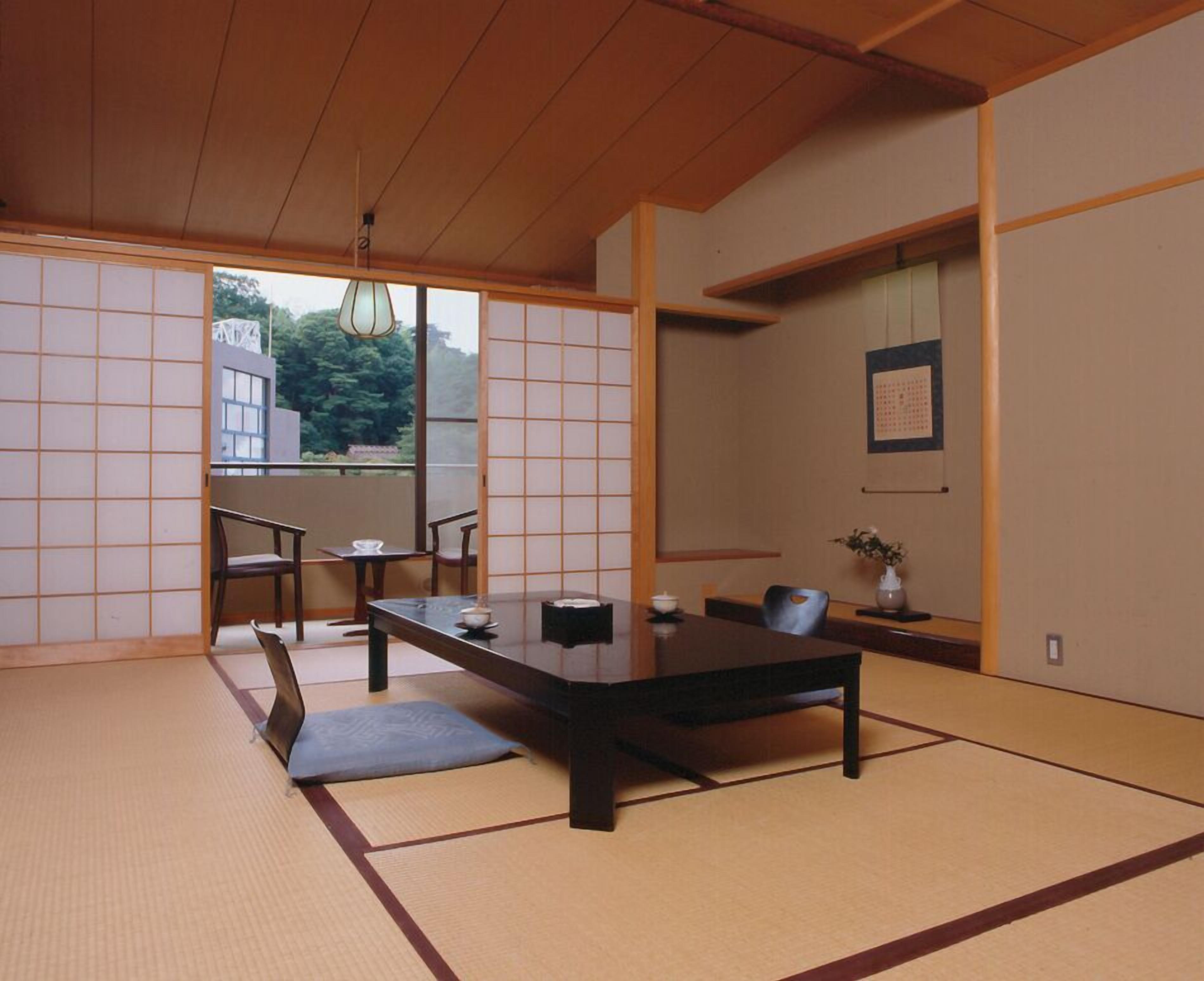 A traditional Japanese room with tatami flooring, a low table, and sliding doors.