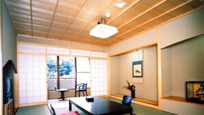 Une pièce de style japonais traditionnel, avec un sol recouvert de tatamis, une table basse et un canapé.