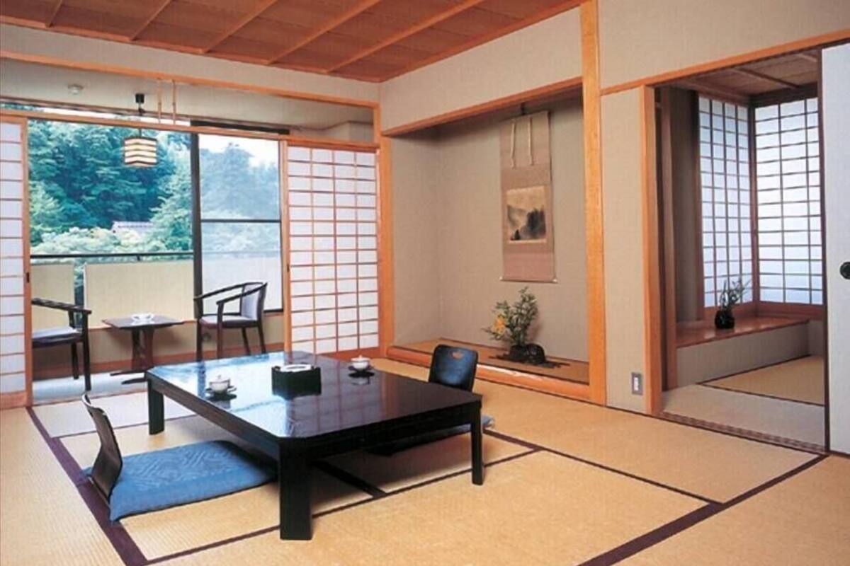 A traditional Japanese room with tatami flooring, a low table, and sliding doors.